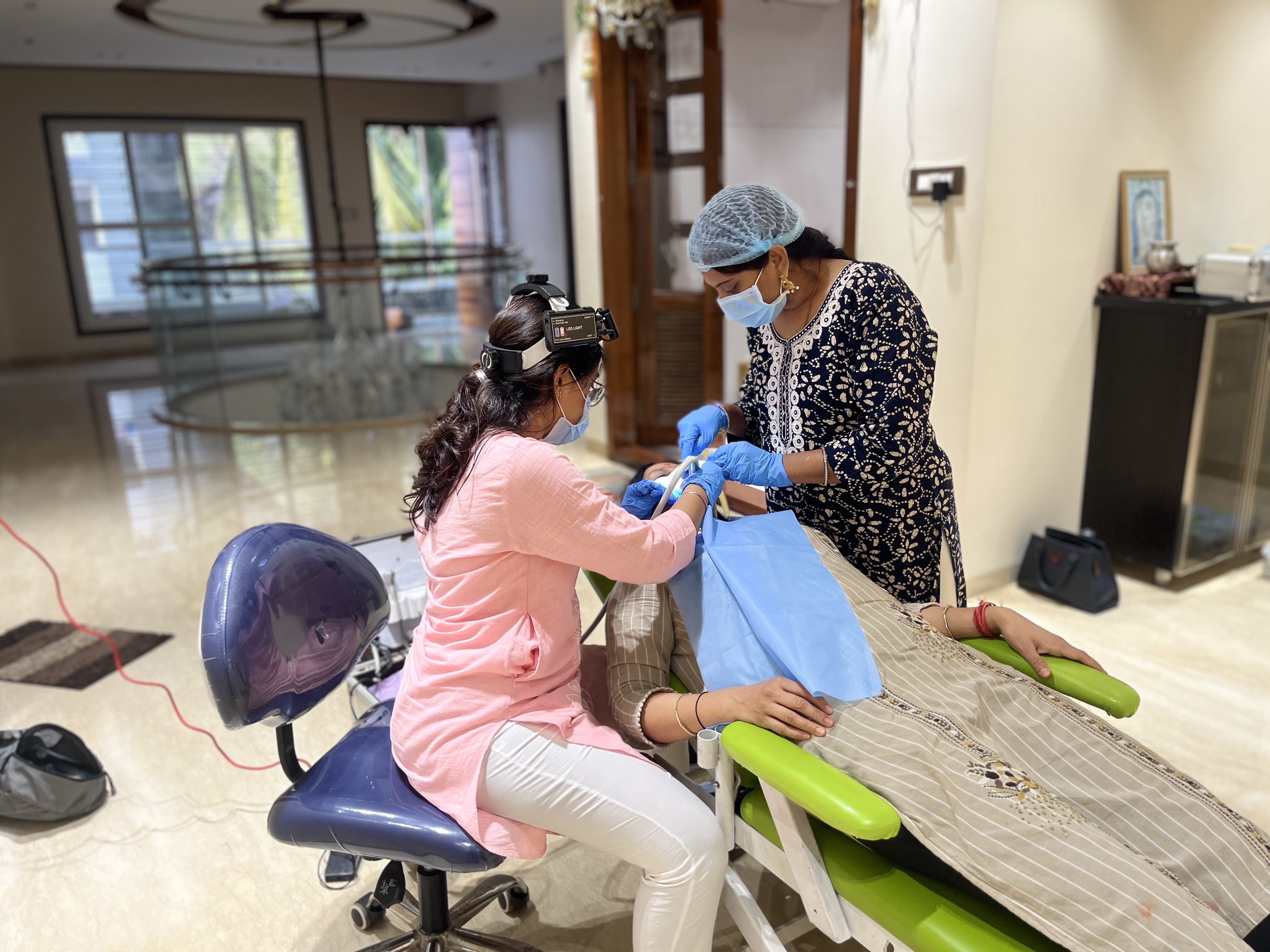 Prudentoe dentist and assistant using portable dental equipment during a home visit in Hyderabad
