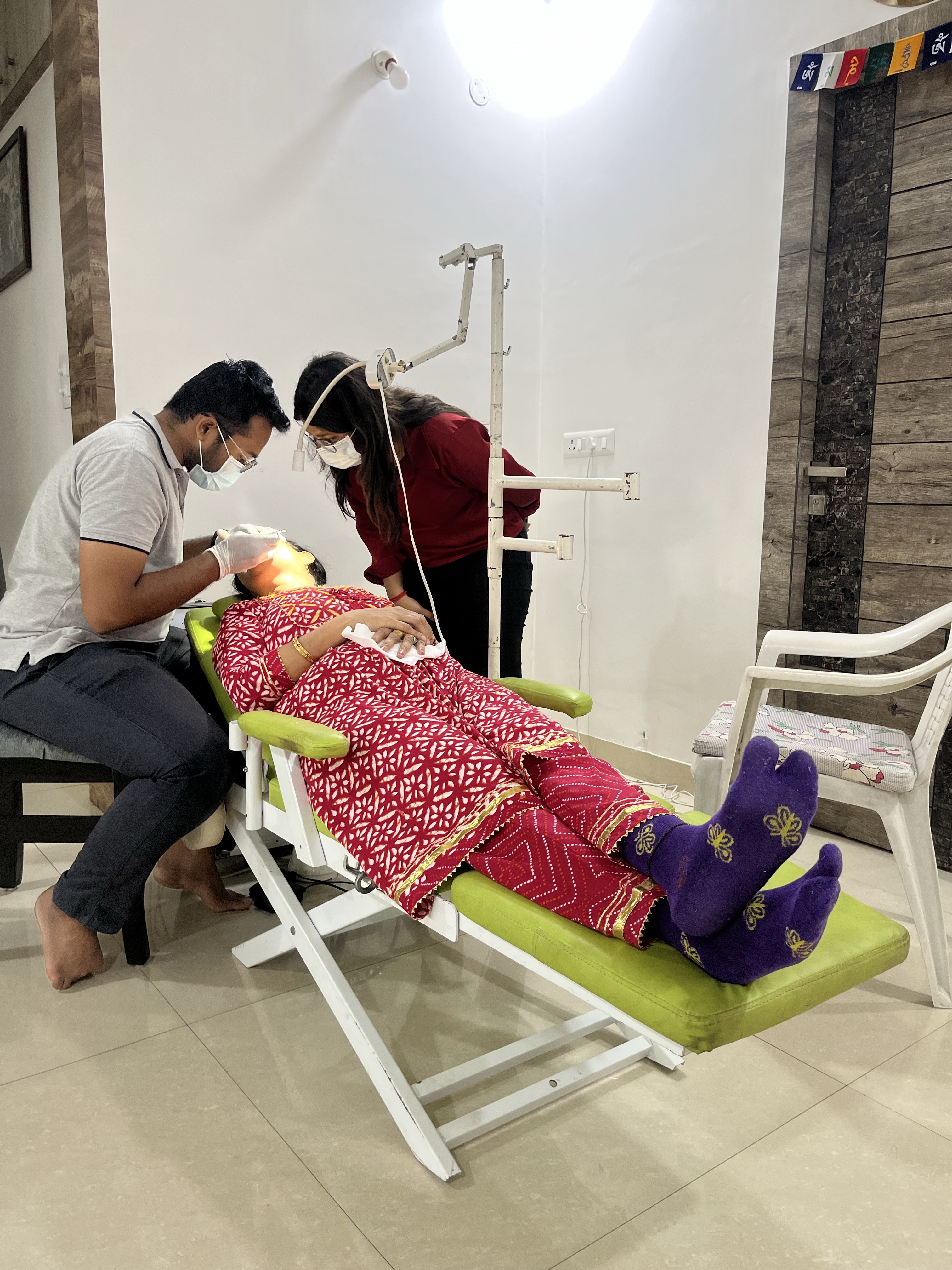 Two Prudentoe dentists performing dental treatment at a patient's home in Hyderabad